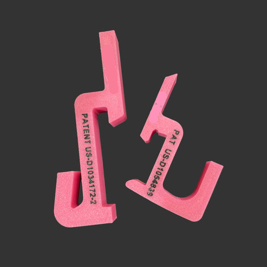 Set of pink plastic tools with patent markings on a black background